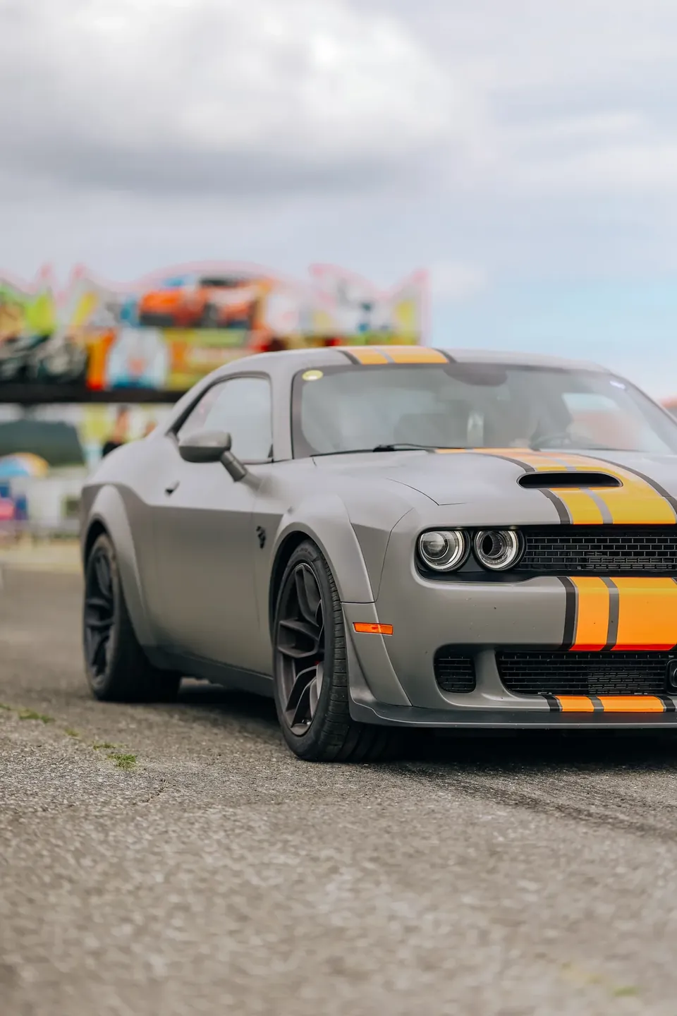 Šedý Dodge Challenger s oranžovými pruhy na kapotě zepředu